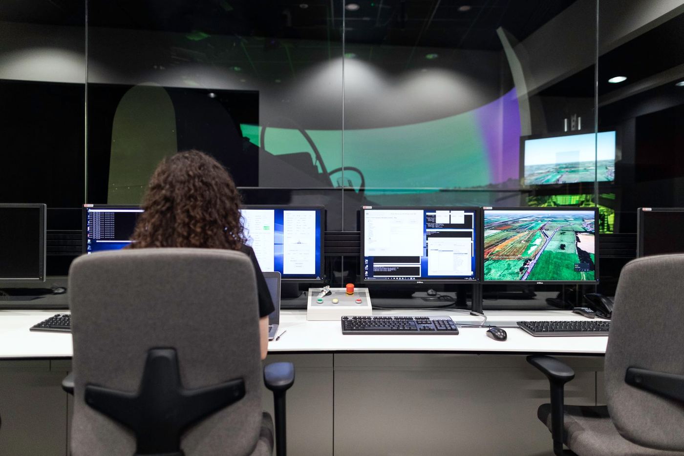Operator monitoring multiple screens in a control room